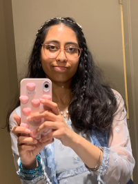 A selfie of Batool Kazmi wearing a blue dress. She is wearing a small silver crown on her head. Her hair is half braided and half down.